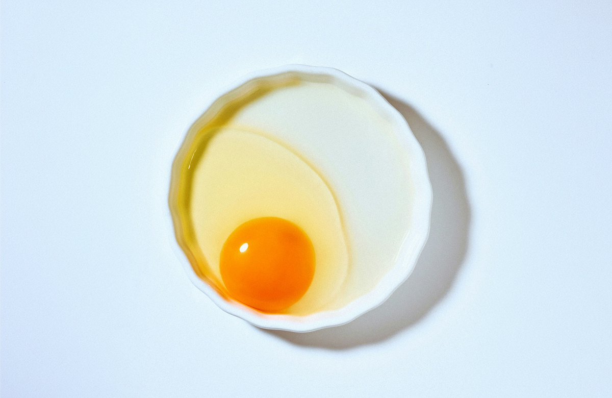 A cracked egg on a white background.