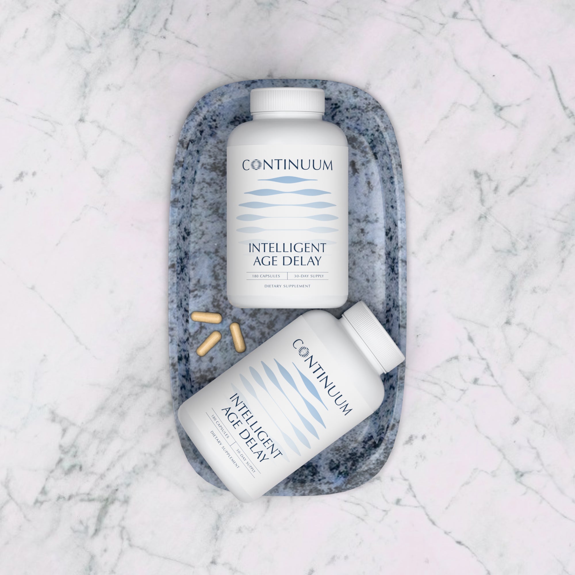 Two bottles of Continuum Intelligent Age Delay supplement on a marble surface