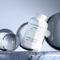 Supplement bottle labeled 'Continuum Intelligent Age Delay' on a reflective surface with abstract shapes.